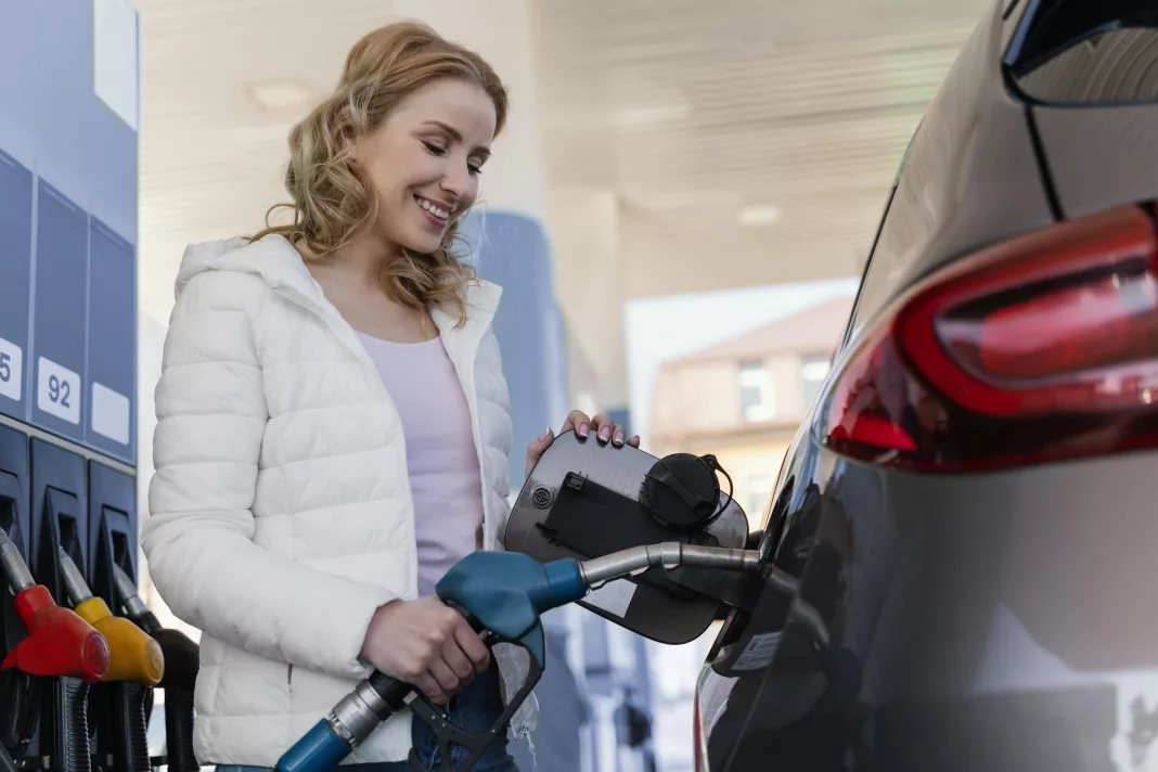 Vrouw lacht om de benzine prijs in Belgie