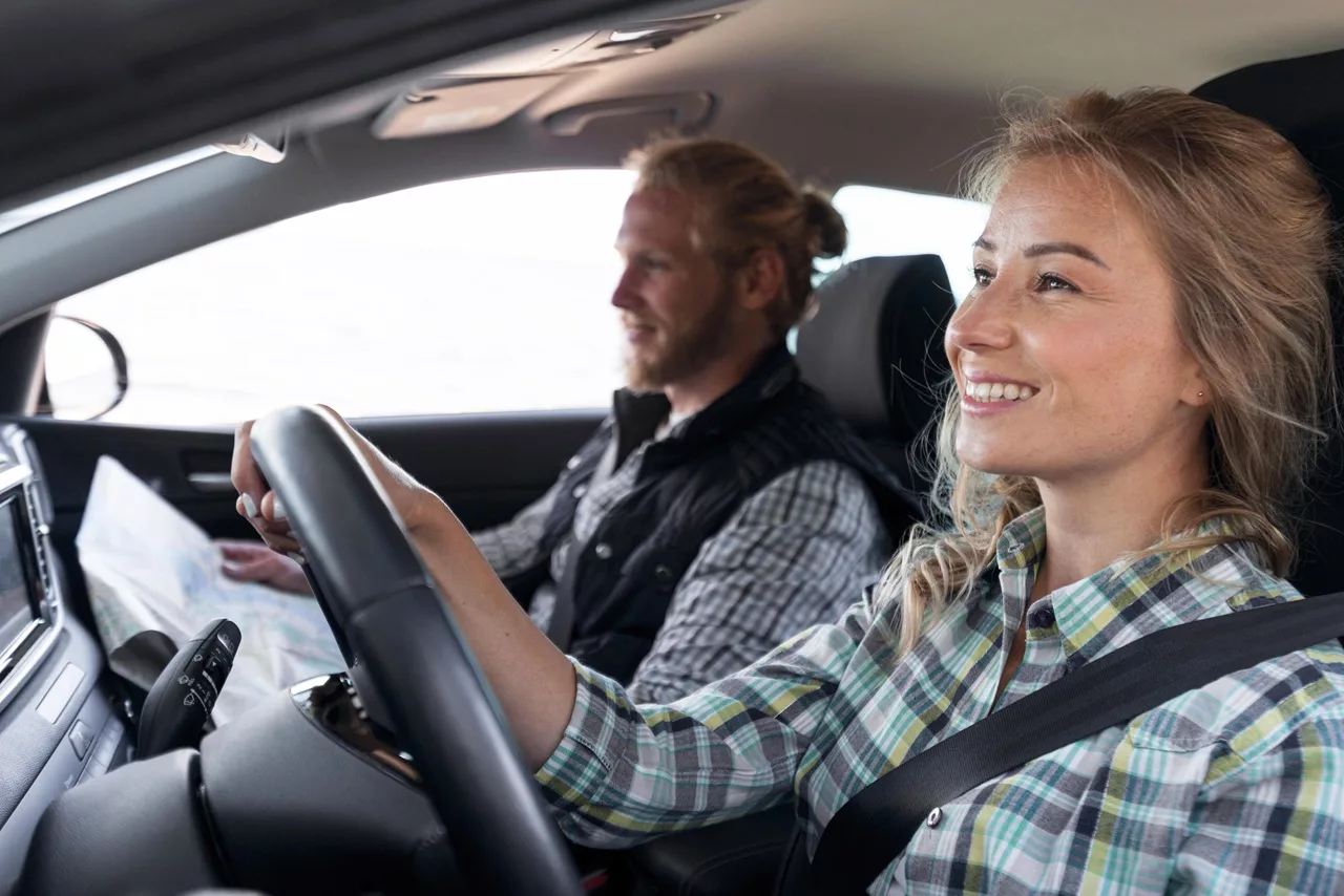 Vrouw heeft rijles met een instructeur naast zich