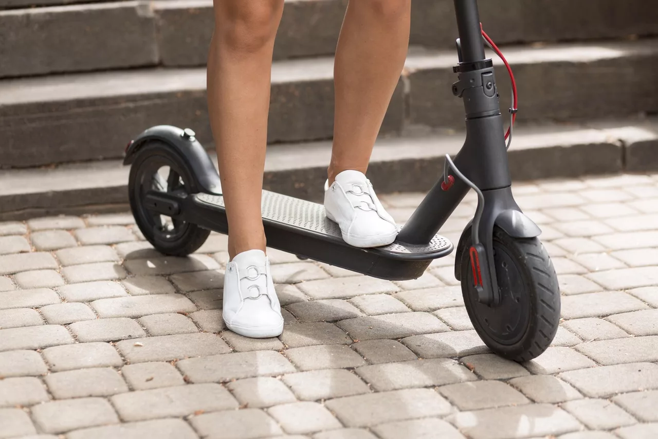 Vrouw staat op elektrische step