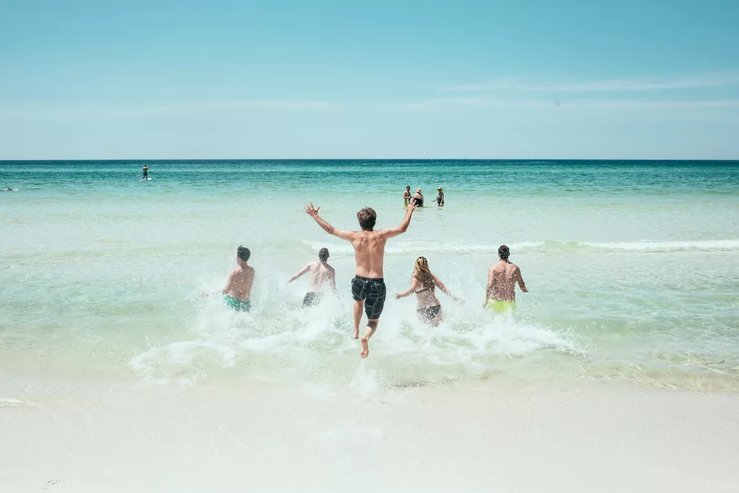 Toeristen rennen het water in op zomervakantie