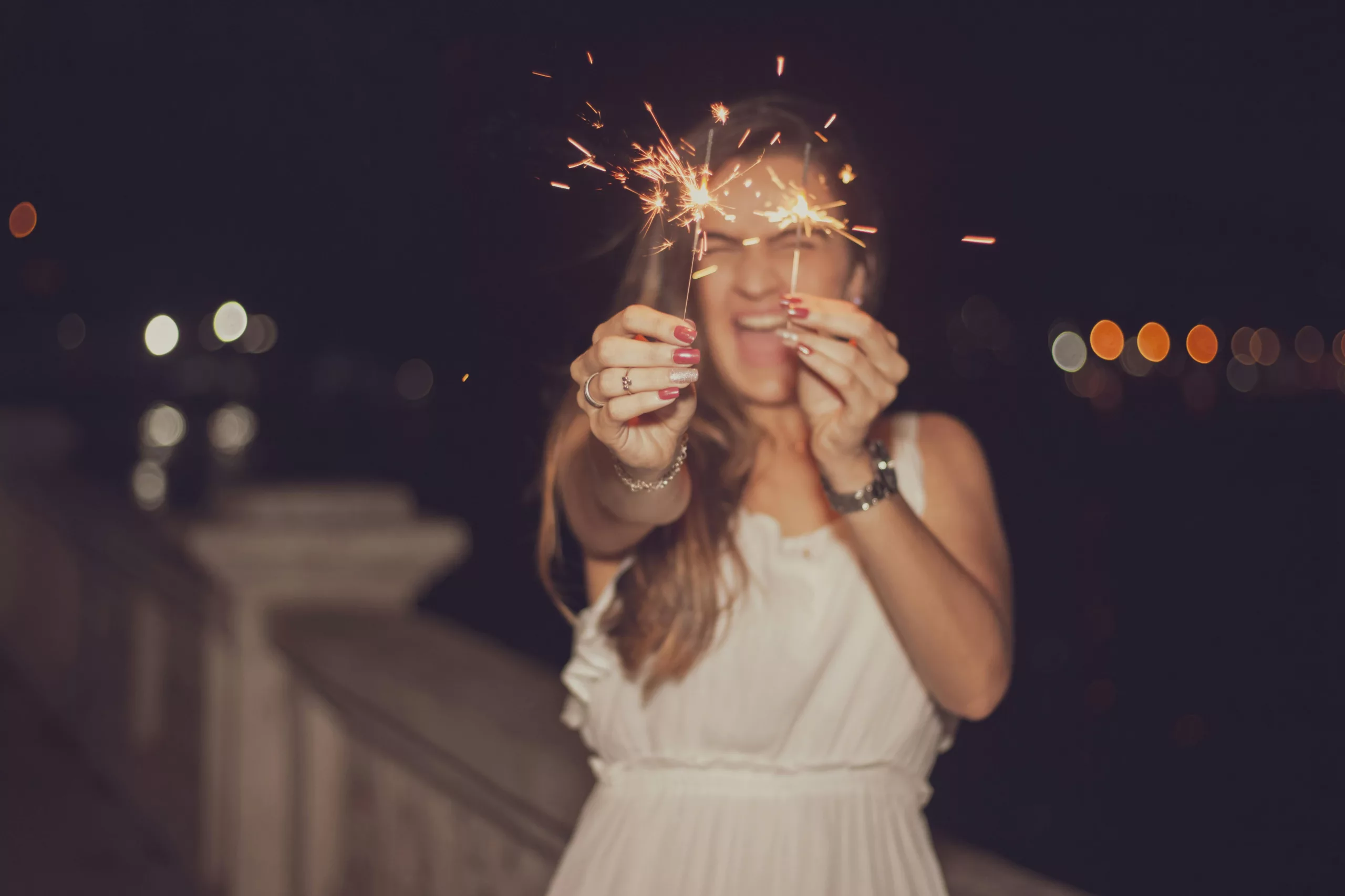 Vrouw viert nieuw jaar met twee sterretjes in haar handen
