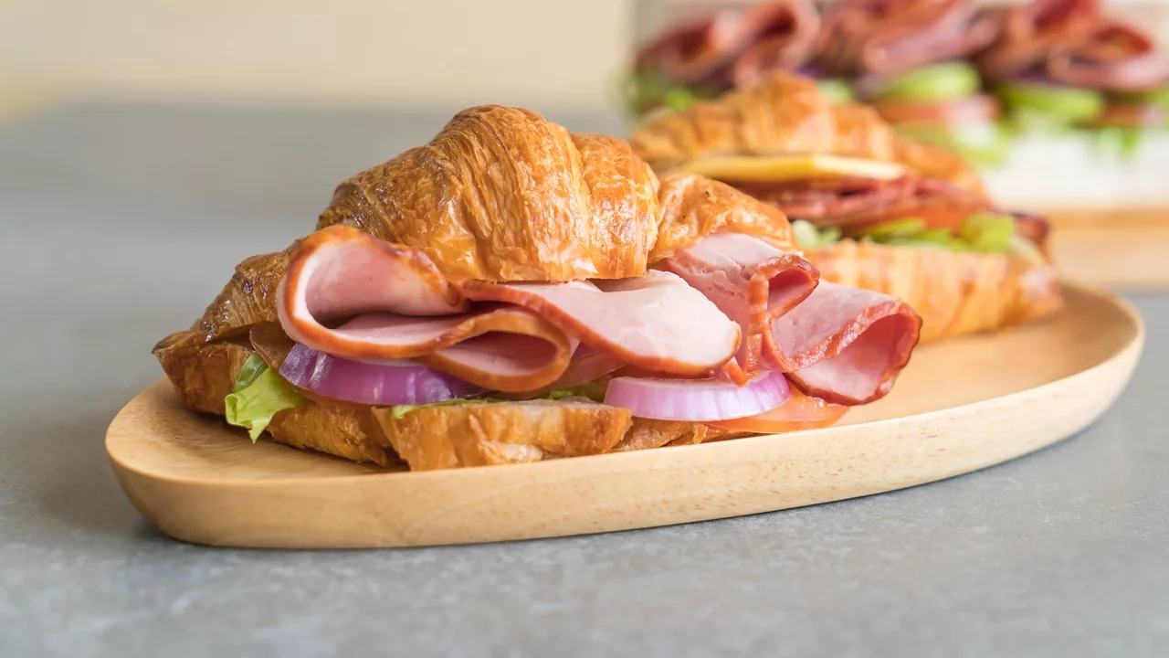 Een croissant belegd met ham en ui