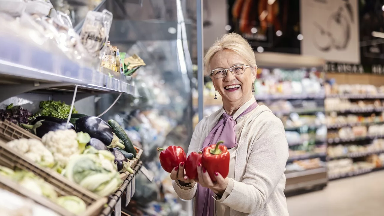 Vrouw houdt paprika's uit de supermarkt in haar handen