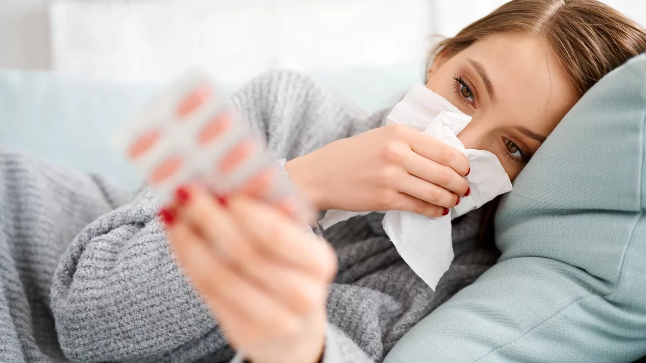 Vrouw is getroffen door de griepepidemie en ligt op de bank