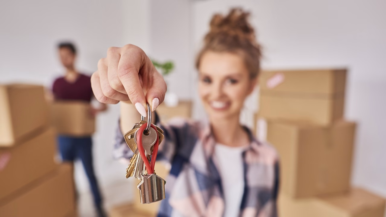 Vrouw toont de sleutels van haar nieuwe woning